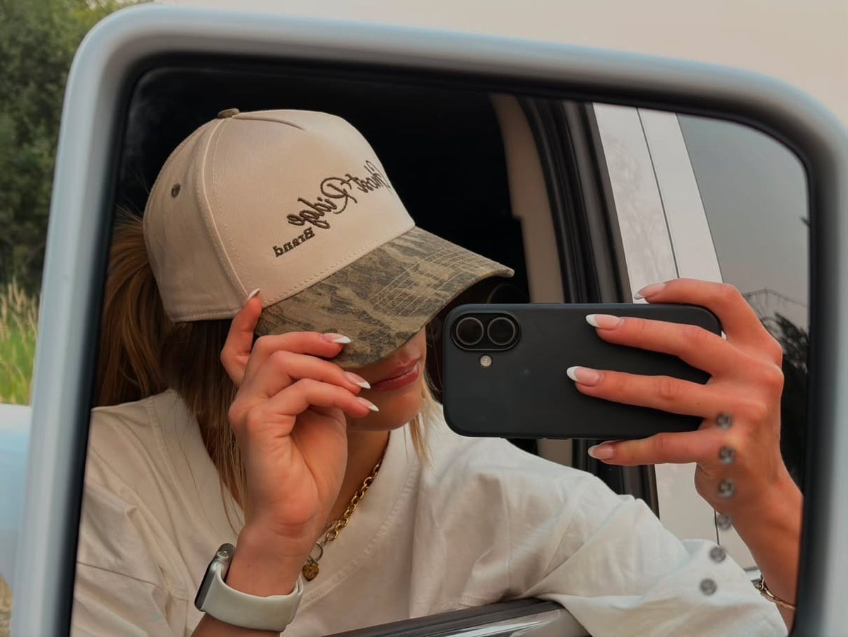 Customer wearing a Ghost Ridge Brand camo bill cap in a truck mirror selfie